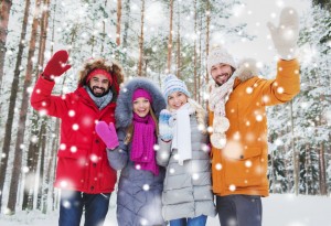 group of friends waving hands in winter forest