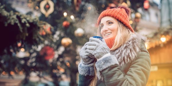 Frau trinkt Glühwein auf dem Weihnachtsmarkt